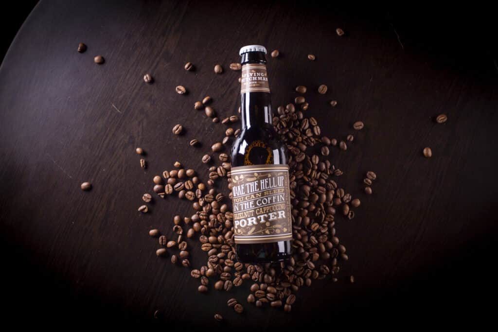 An alcoholic beverage laying on coffee beans.