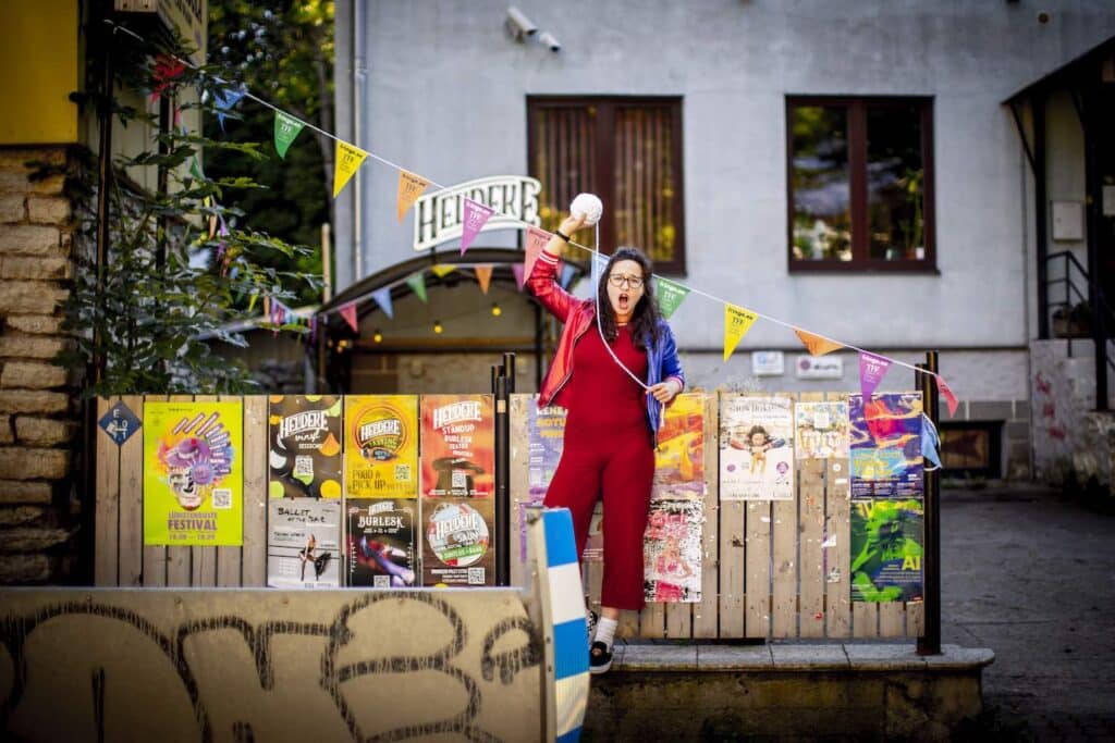 Perfomer woman standing in front of the Heldeke venue in Kalamaja Tallinn as part of the Tallinn Fringe Festival